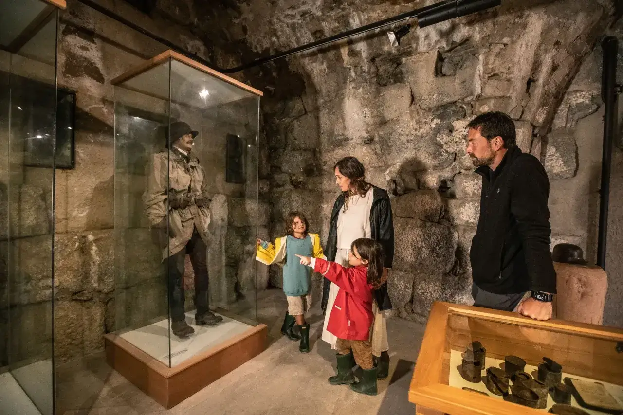 Famiglia visita un manichino in uniforme in un museo, forse all'interno di un forte strino.