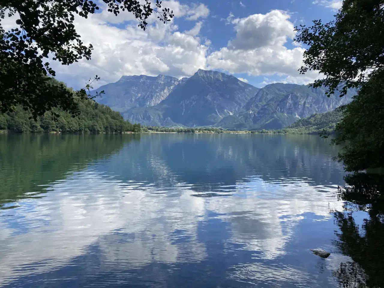 Lago di Levico, con montagne maestose e cielo azzurro. Un luogo incantevole da scoprire, tra le cose da vedere a Levico Terme.