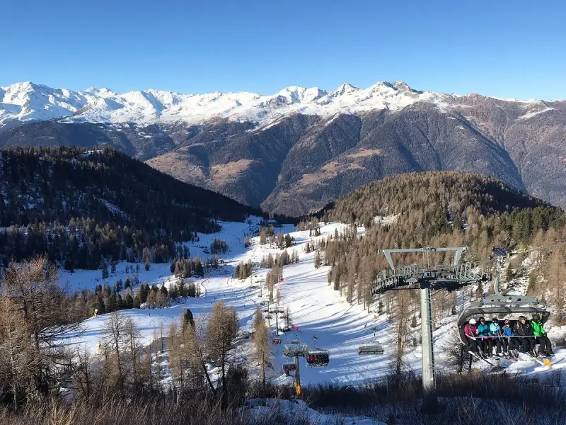 Impianti di risalita a Folgarida, dove si trova questo paesaggio innevato con montagne maestose e piste da sci.